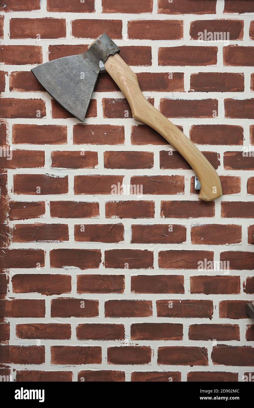 Große Axt hängt an einer Ziegelwand Stockfoto