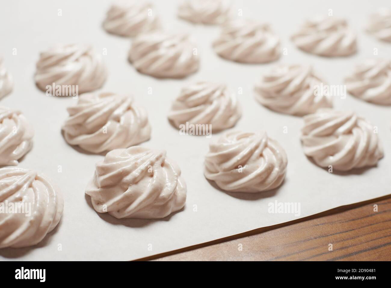 Gekochte hausgemachte Baiser Plätzchen auf Backpapier, hausgemachte Süßspeisen Stockfoto