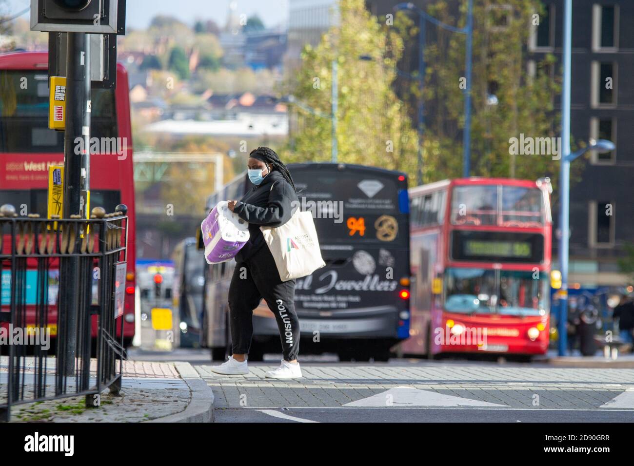 Frau trägt mehrere Päckchen Toilettenpapier, da Großbritannien eine weitere einmonatige Sperre, Birmingham, eingehen soll Stockfoto