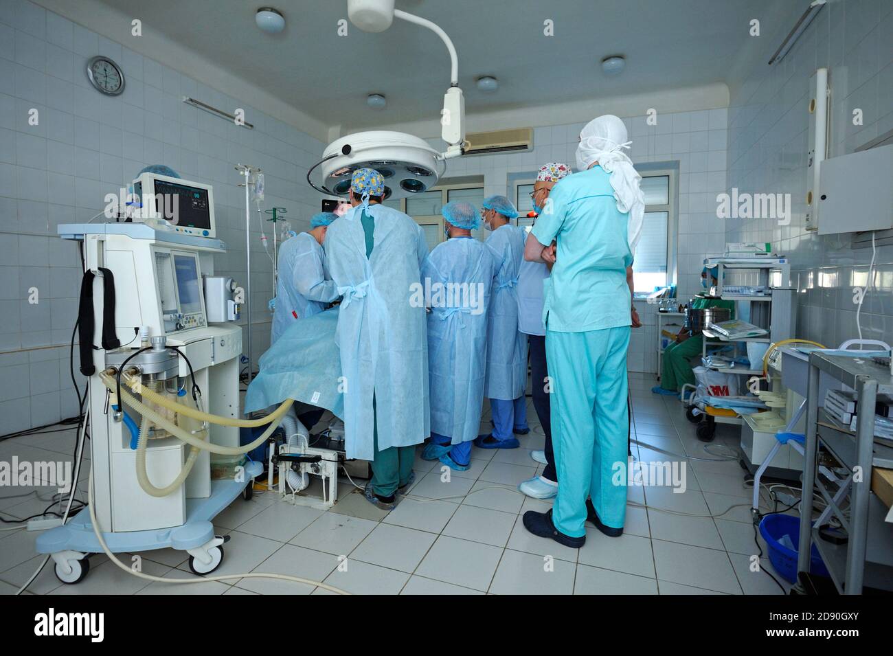 Im Operationssaal. Chirurgen, die um die Patientenplatte stehen und eine Operation durchführen Stockfoto