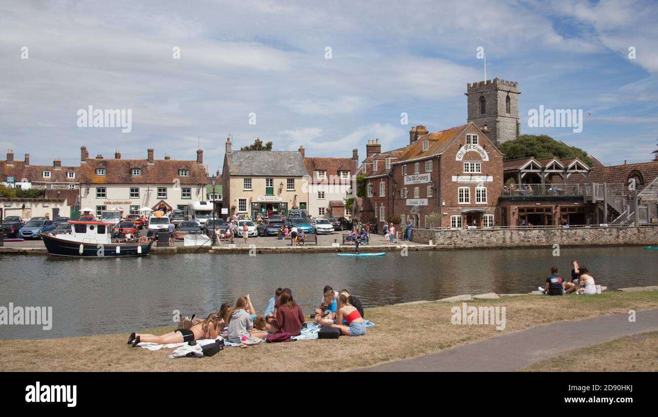 Jugendliche saßen am 23. Juli 2020 am River Frome in Wareham, Dorset in Großbritannien Stockfoto