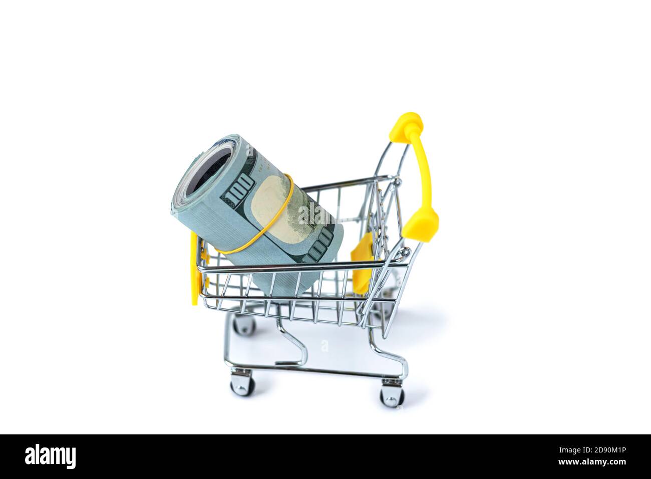 Kleiner Einkaufswagen gefüllt mit gewellten Bargelddollar. Dollar in einem gelben Trolley. Das Konzept von Ausgaben und Shopping. Isoliert. Stockfoto