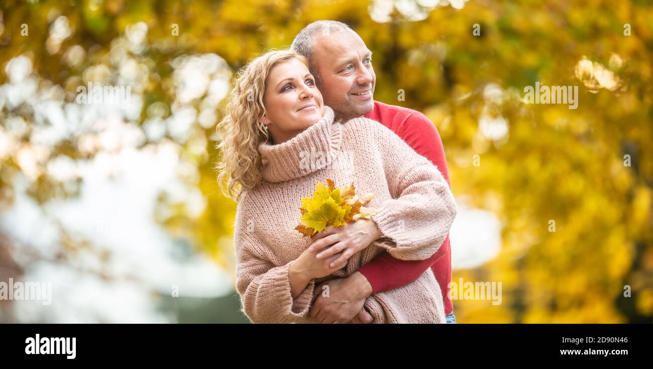 Blatt, das von einem verliebten Paar in einer lebendigen, farbenfrohen Natur guckt. Stockfoto