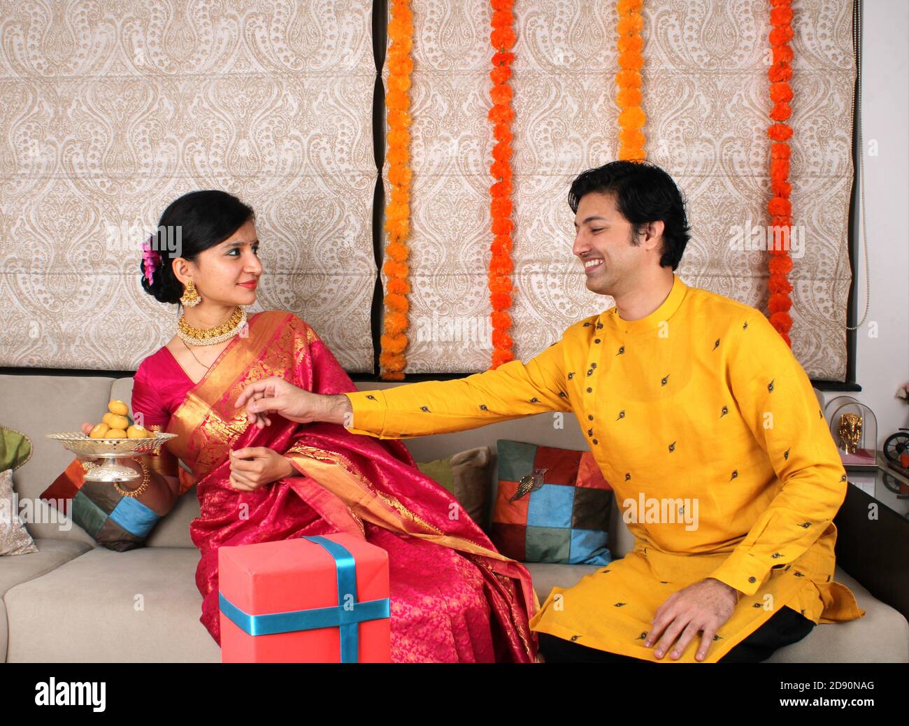 Indisches Paar mit Süßigkeiten und Geschenken während der Feier Diwali, Deepavali oder Dipavali Festival. Stockfoto
