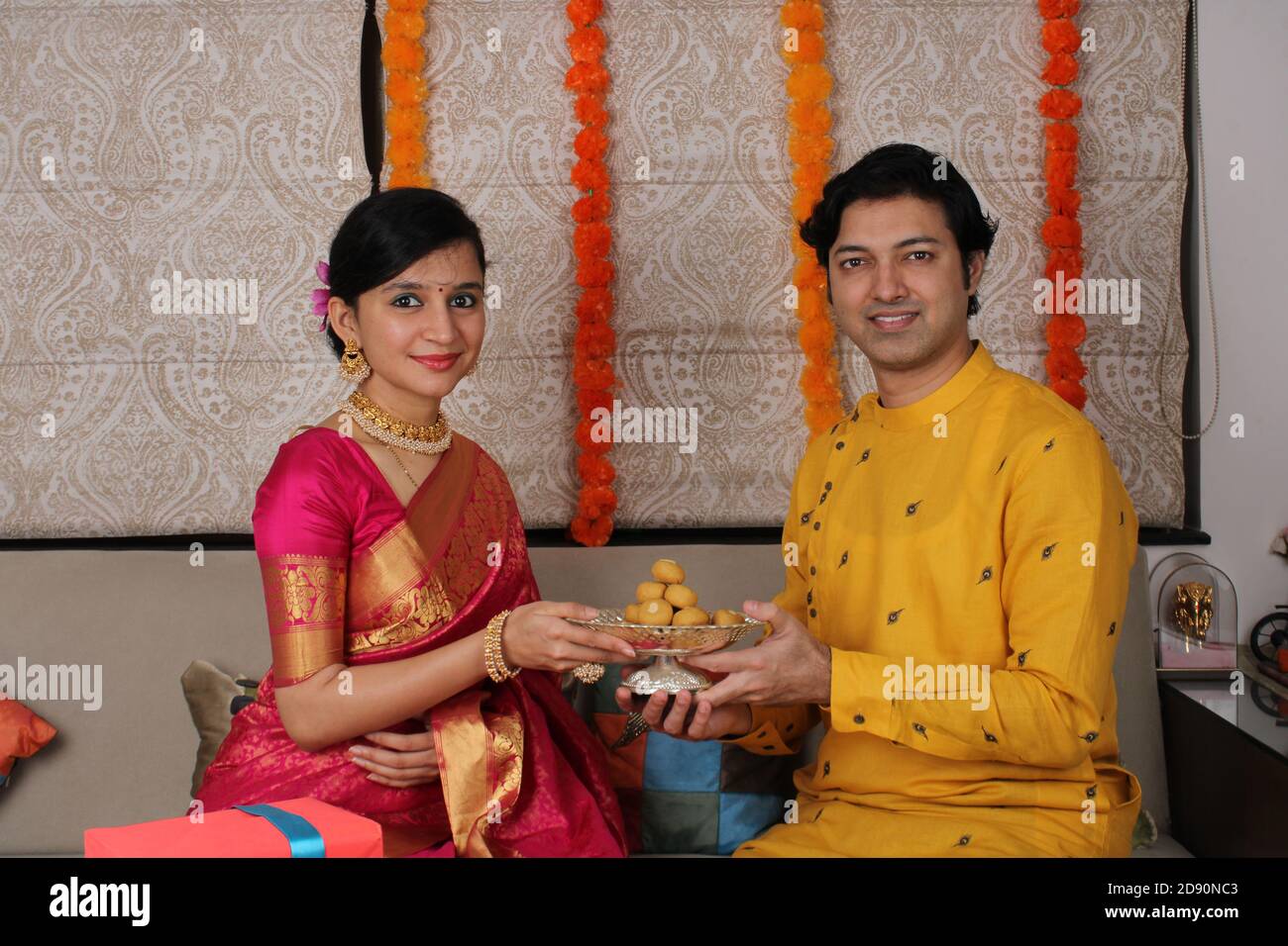 Indisches Paar mit Süßigkeiten und Geschenken während der Feier Diwali, Deepavali oder Dipavali Festival. Stockfoto
