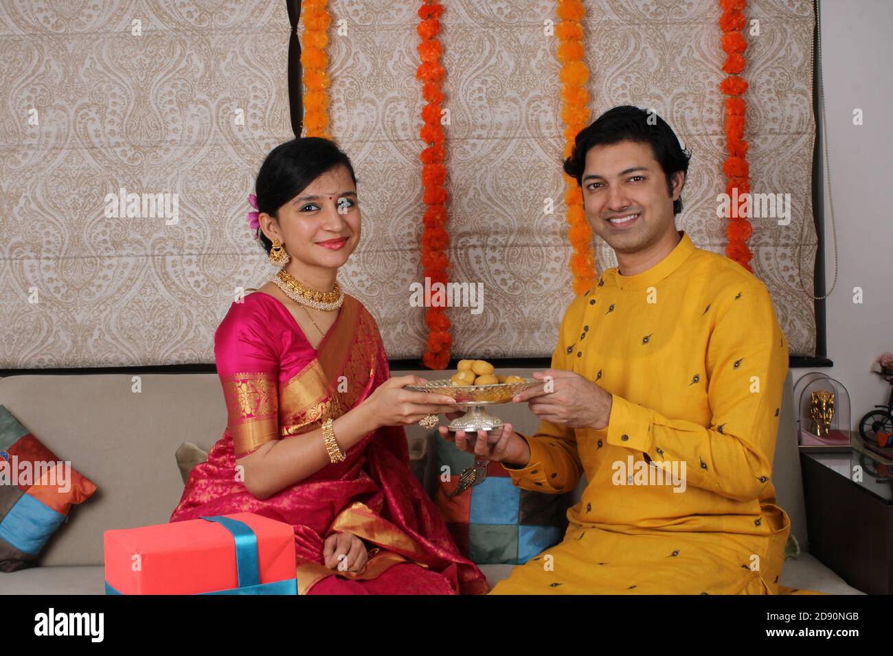 Indisches Paar mit Süßigkeiten und Geschenken während der Feier Diwali, Deepavali oder Dipavali Festival. Stockfoto