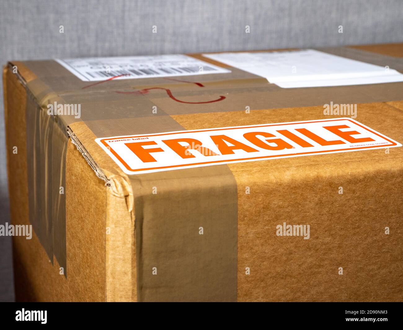 Nahaufnahme einer versiegelten und ungeöffneten Kartonverpackung mit einem zerbrechlichen Etikett auf der Verpackung. Stockfoto