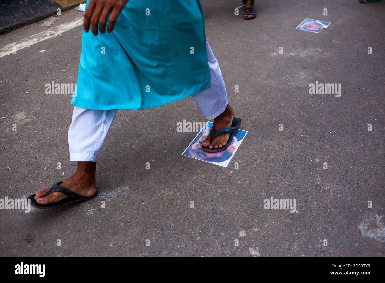 Während des protestmarsches in Dhaka wird ein muslimischer Protestant über ein Porträt des französischen Präsidenten Emmanuel Macron gesehen.Tausende von Hefazat-e-Islam-Führern und Aktivisten aus Bangladesch nehmen an einem Anti-Frankreich-protestmarsch Teil, der zum Boykott französischer Produkte aufruft und den französischen Präsidenten Emmanuel Macron für seine Äußerungen anprangert ‘nicht aufgeben Cartoons Darstellung Propheten Mohammed’. Hefazat-e-Islam Bangladesch hat der Regierung ein 24-Stunden-Ultimatum zur Schließung der französischen Botschaft in Dhaka gestellt. Stockfoto