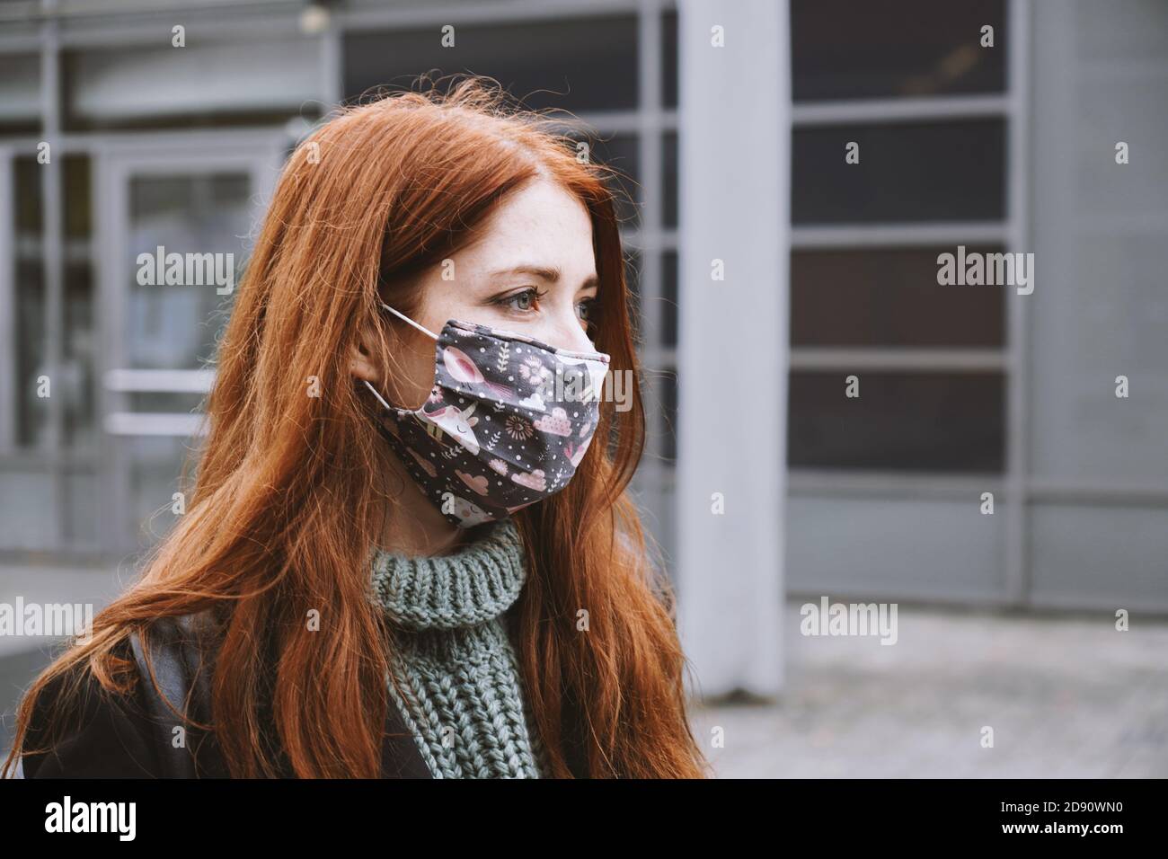 Junge Frau trägt hausgemachte Alltag Stoff Gesichtsmaske im Freien in der Stadt, neue normale covid-19 Corona-Virus Pandemie oder Luftverschmutzung Konzept, echte Menschen Lebensstil im Winter Stockfoto