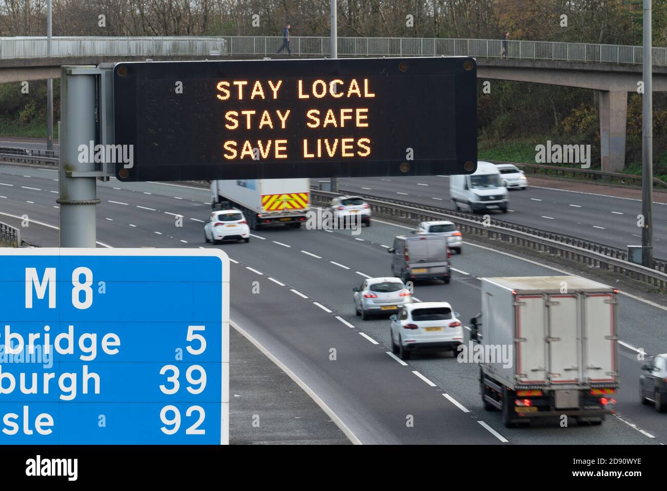 Glasgow, Schottland, Großbritannien. November 2020. Autofahrer passieren Autobahnbrücke mit Covid-19 Gesundheitsberatung Nachricht auf der M8 in Glasgow, als Schottland neue Coronavirus Lockdown-Vorschriften mit dem zentralen Gürtel und Glasgow in Ebene 3 platziert. Iain Masterton/Alamy Live News Stockfoto