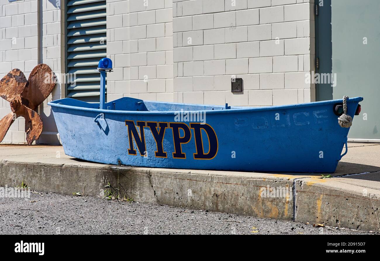 Dieses alte Dingy sitzt vor dem NYPD Harbor Unit Hauptquartier in Sunset Park, Brooklyn NY Stockfoto