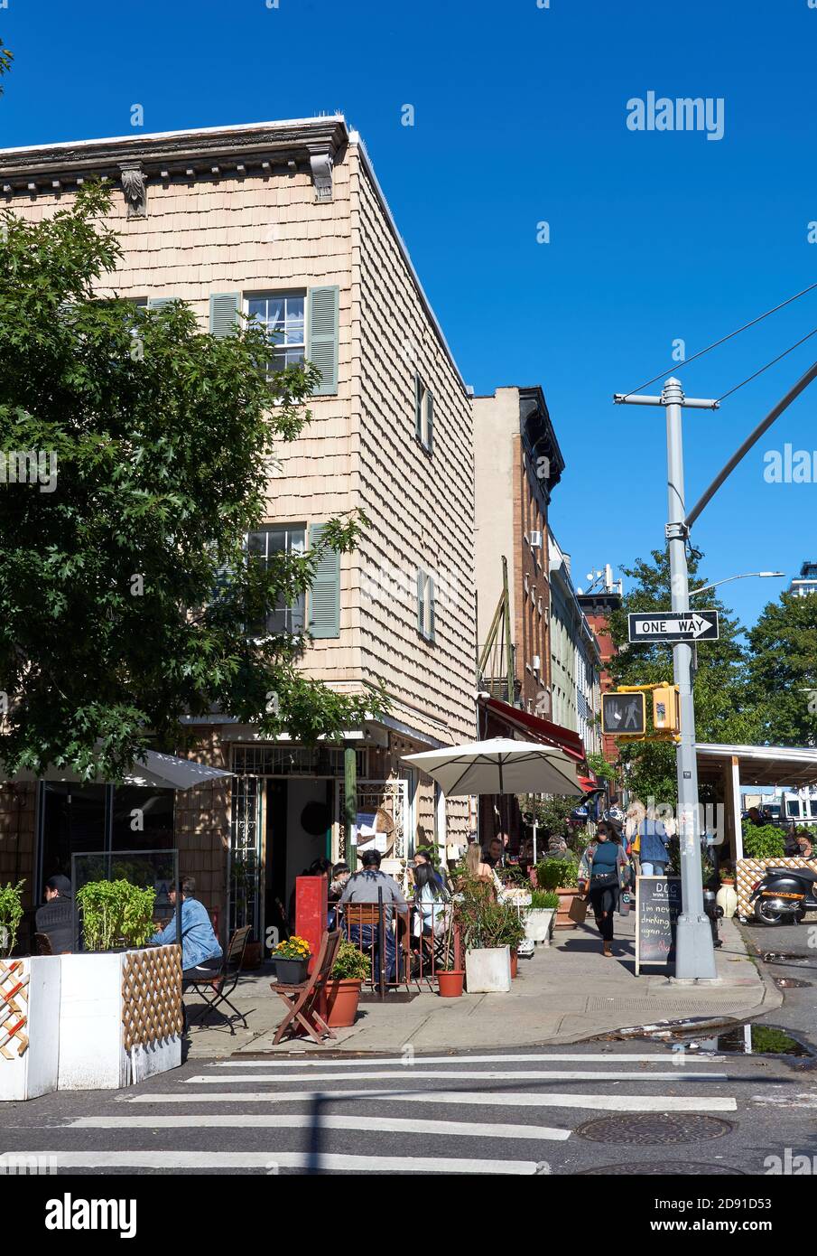 Ein Café in einem alten Schindelgebäude an einer Straßenecke in Williamsburg, Brooklyn, NY. Sitzplätze im Freien sind erforderlich. Stockfoto