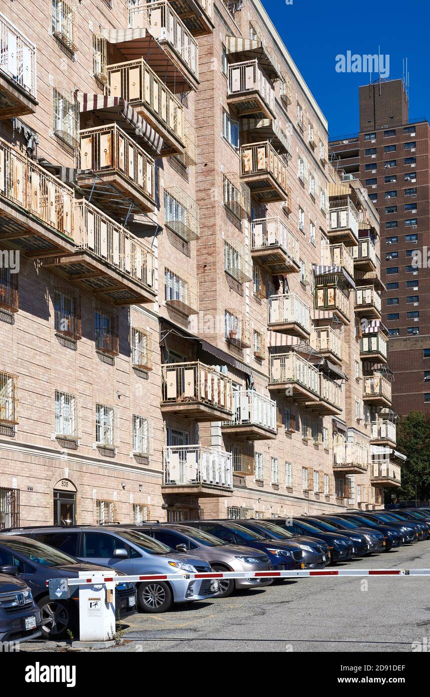 Ein Mehrfamilienhaus mit Balkonen in South Williamsburg, Brooklyn, NY. An der Seite des Gebäudes befindet sich eine lange Reihe von Autos. Stockfoto