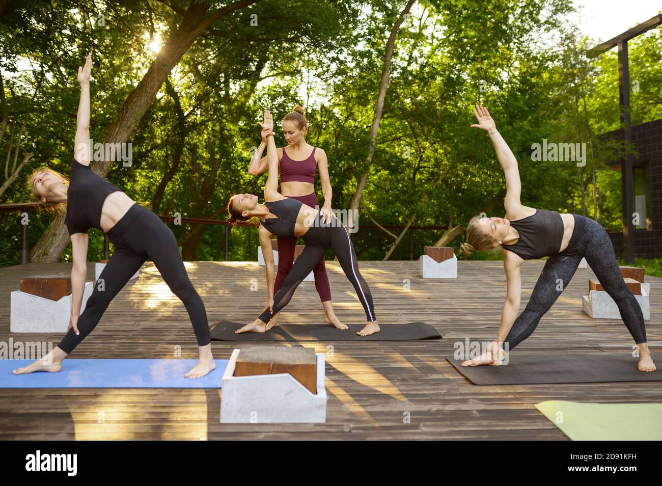 Frauen tun Übung mit Lehrer, Gruppe Yoga Stockfoto