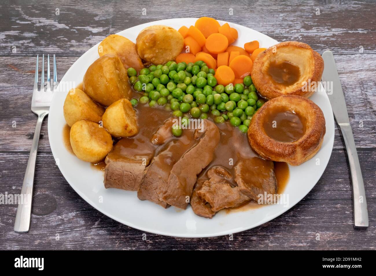 Traditionelles Sonntagabend mit Roastbeef, Bratkartoffeln, Gemüse und yorkshire Puddings mit Soße Stockfoto