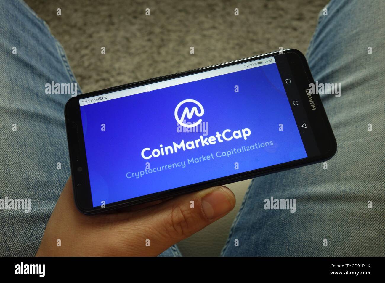 Mann hält Smartphone mit Coinmarketcap Website-Logo Stockfoto