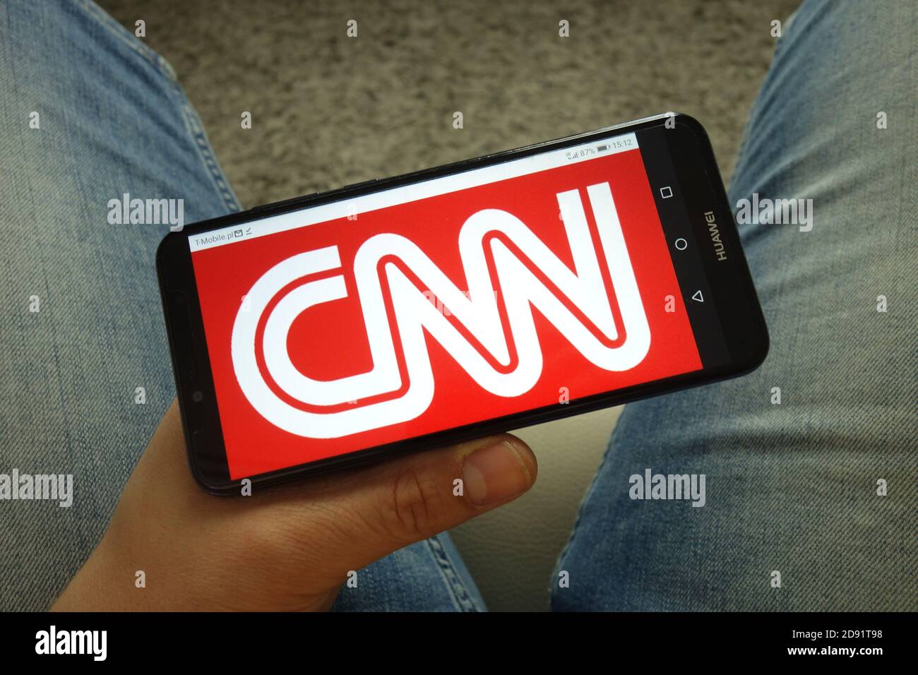 Mann hält Smartphone mit CNN TV-Kanal-Logo Stockfoto