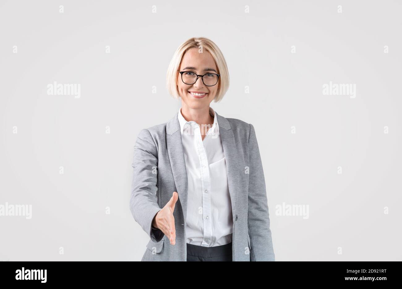 Geschäftsfrau schlägt Deal oder Transaktion, bietet Partnerschaft, geben ihre Hand zum schütteln auf hellgrauem Hintergrund Stockfoto