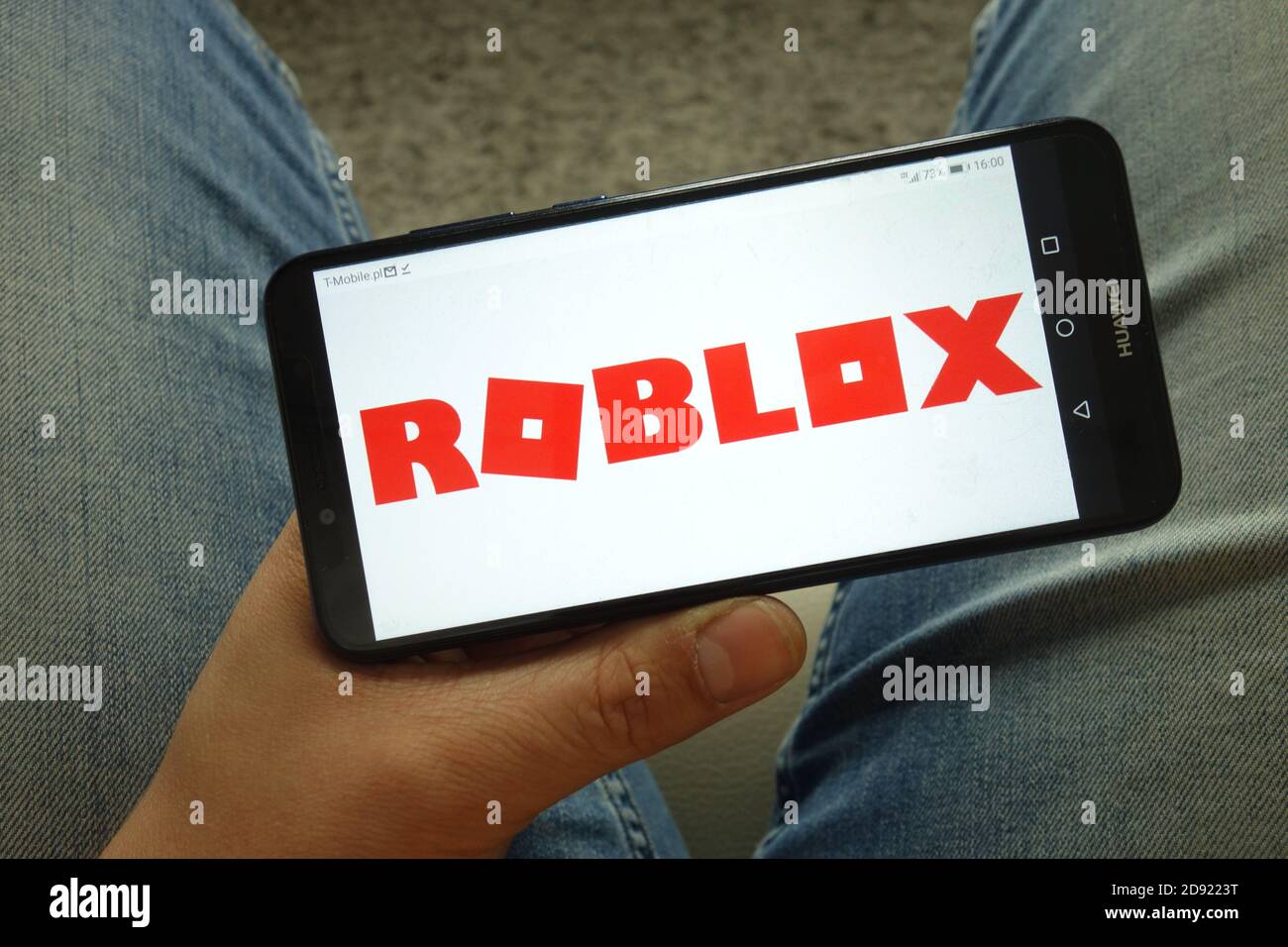 Mann hält Smartphone mit Roblox Plattform-Logo Stockfoto