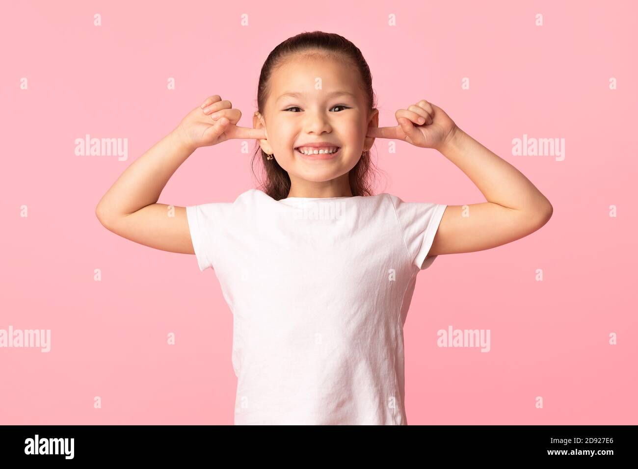 Asiatische Kind kleben Finger in den Ohren und Grimacing Stockfoto