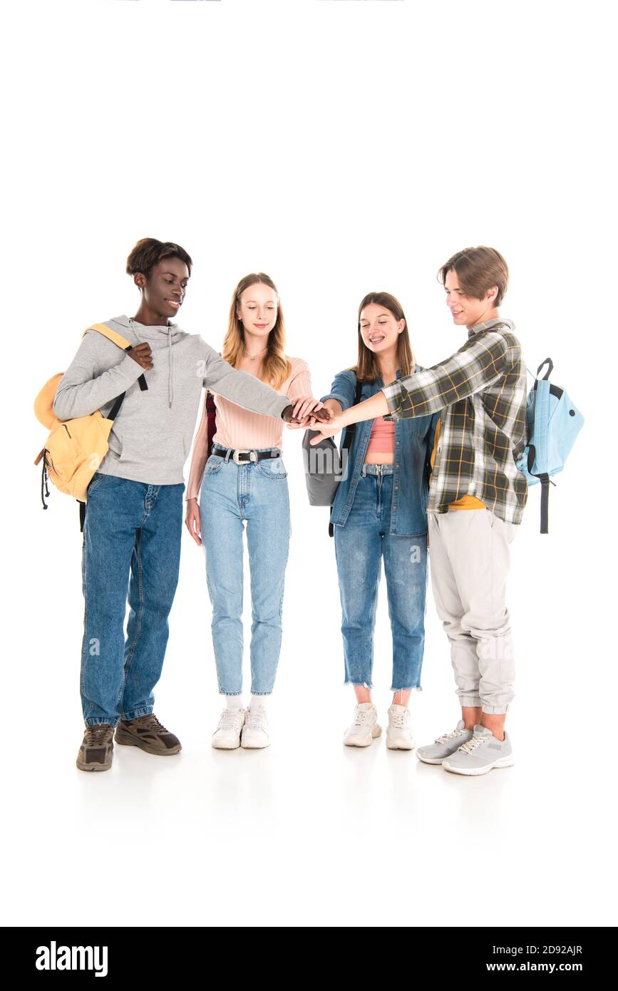 Lächelnde multikulturelle Jugendliche halten Hände auf weißem Hintergrund Stockfoto