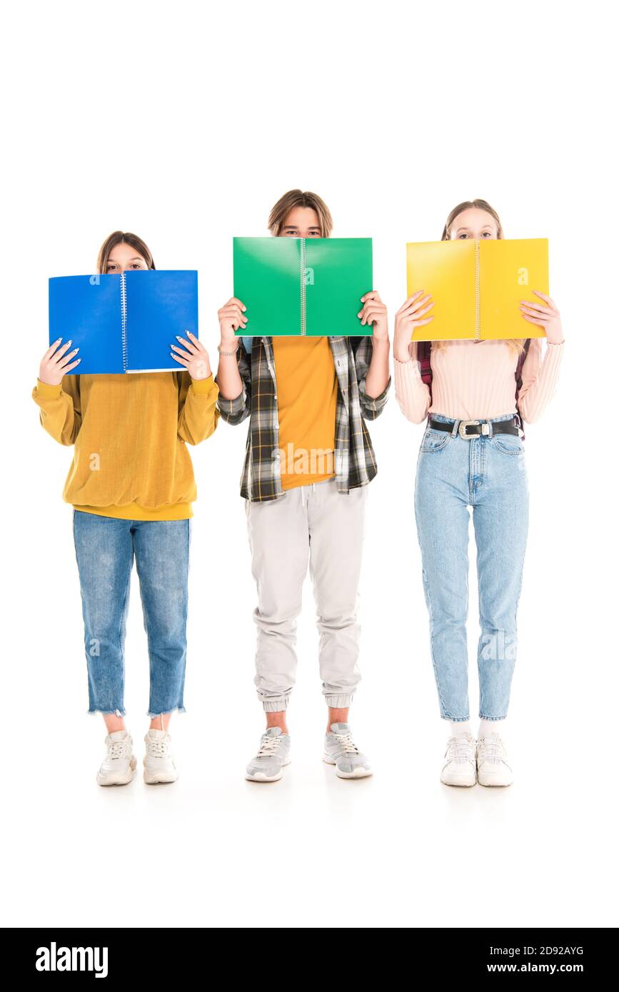 Jugendliche bedecken Gesichter mit Notizbüchern auf weißem Hintergrund Stockfoto