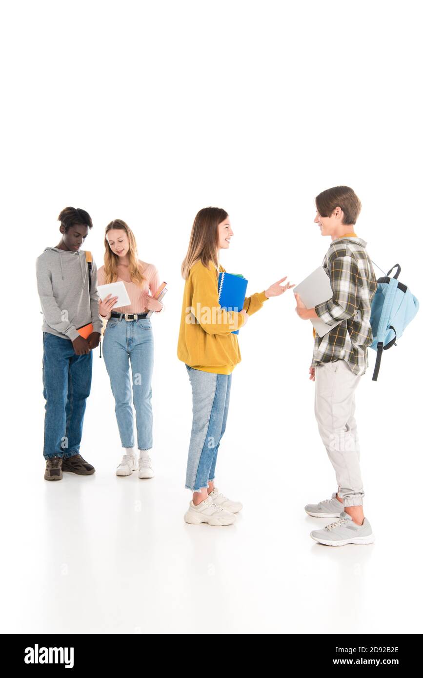 Selektiver Fokus von lächelnden Jugendlichen mit Notebooks und Gadgets reden Auf weißem Hintergrund Stockfoto