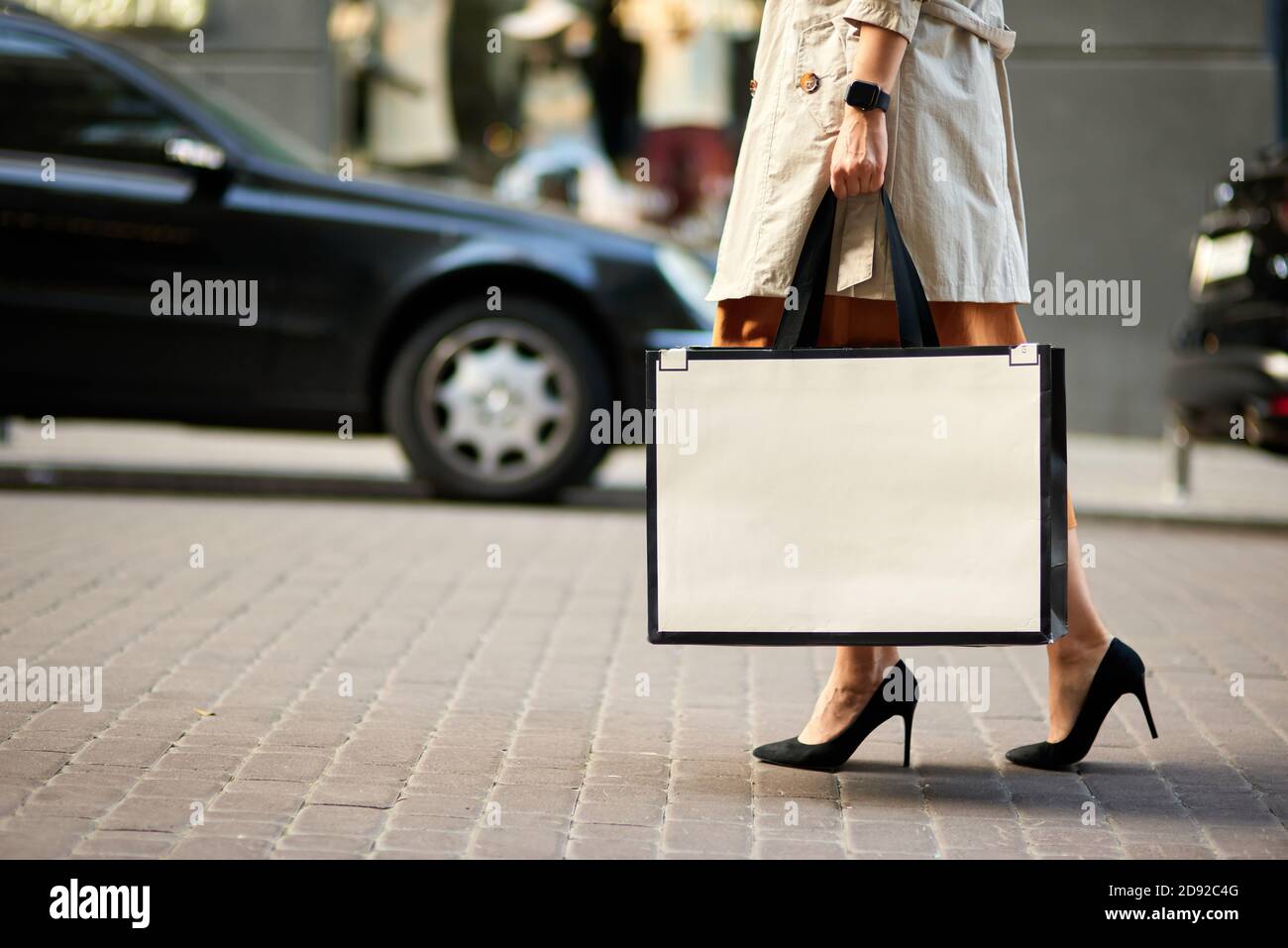 Einkaufstag. Kurze Aufnahme einer Frau in Schuhen mit hohem Absatz, die eine große Einkaufstasche tragen und durch die Straßen der Stadt laufen. Mode, Menschen Lifestyle-Konzept Stockfoto