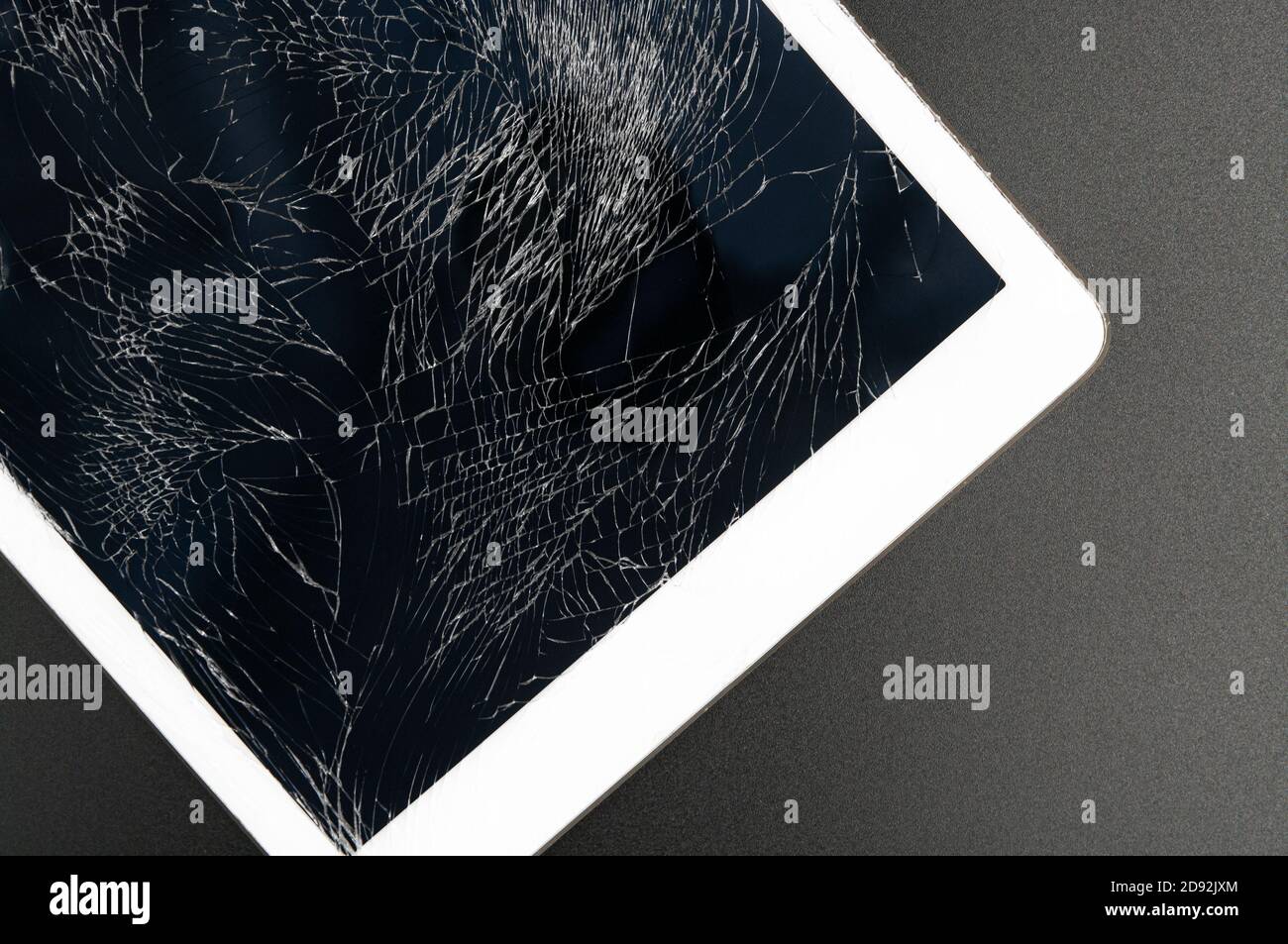 Modernes Tablet mit stark gebrochenem Bildschirm auf schwarzem Hintergrund. Stockfoto