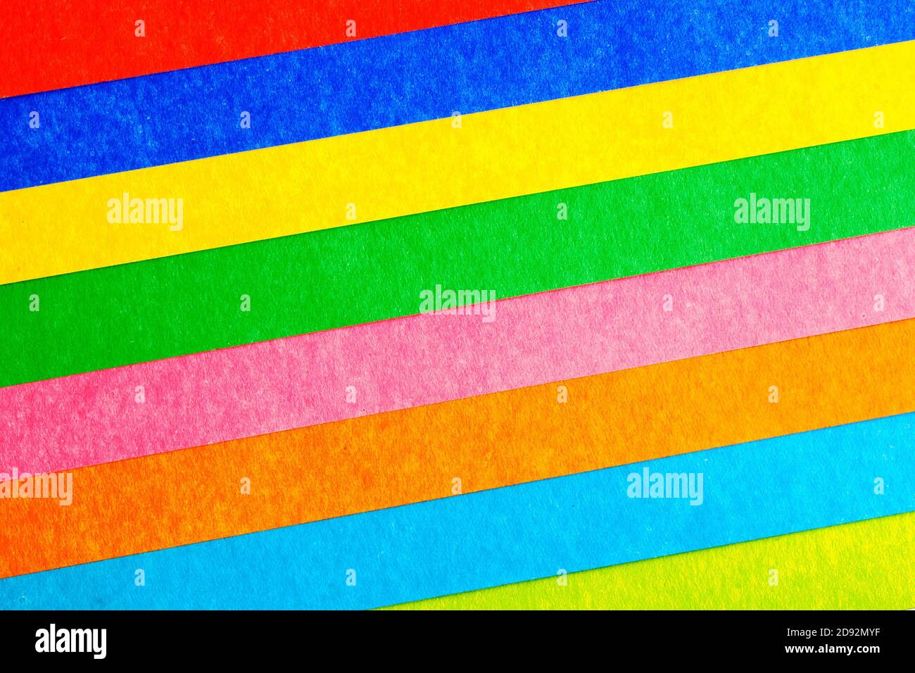 Mehrfarbige Streifen in einem Winkel aus Pappe, abstrakter Hintergrund, Draufsicht Stockfoto