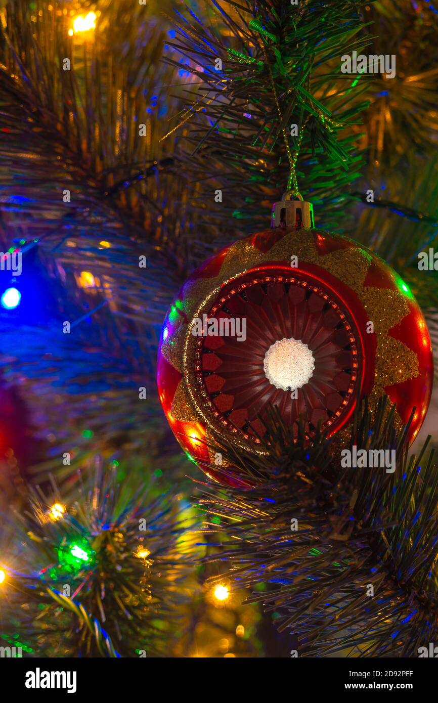 Vertikale Ansicht der roten Kugel und Girlande Lichter auf Weihnachtsbaum, selektive Fokus Stockfoto