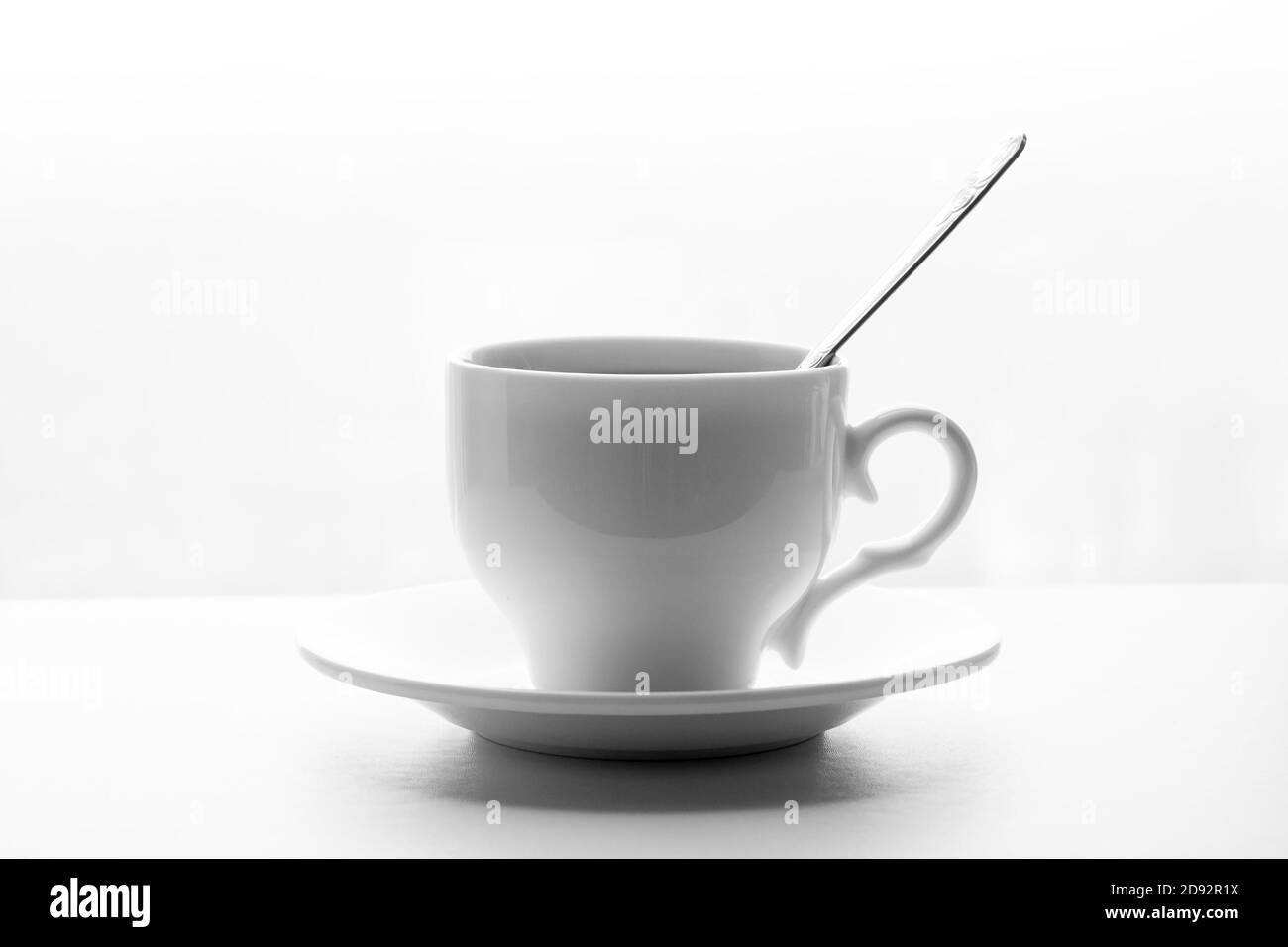 Weiße Tasse Tee oder Kaffee mit Löffel und Untertasse Auf weißem Hintergrund Stockfoto