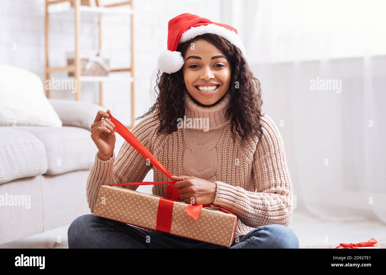 Schwarze Frau Öffnet Geschenkbox Zu Hause Stockfoto