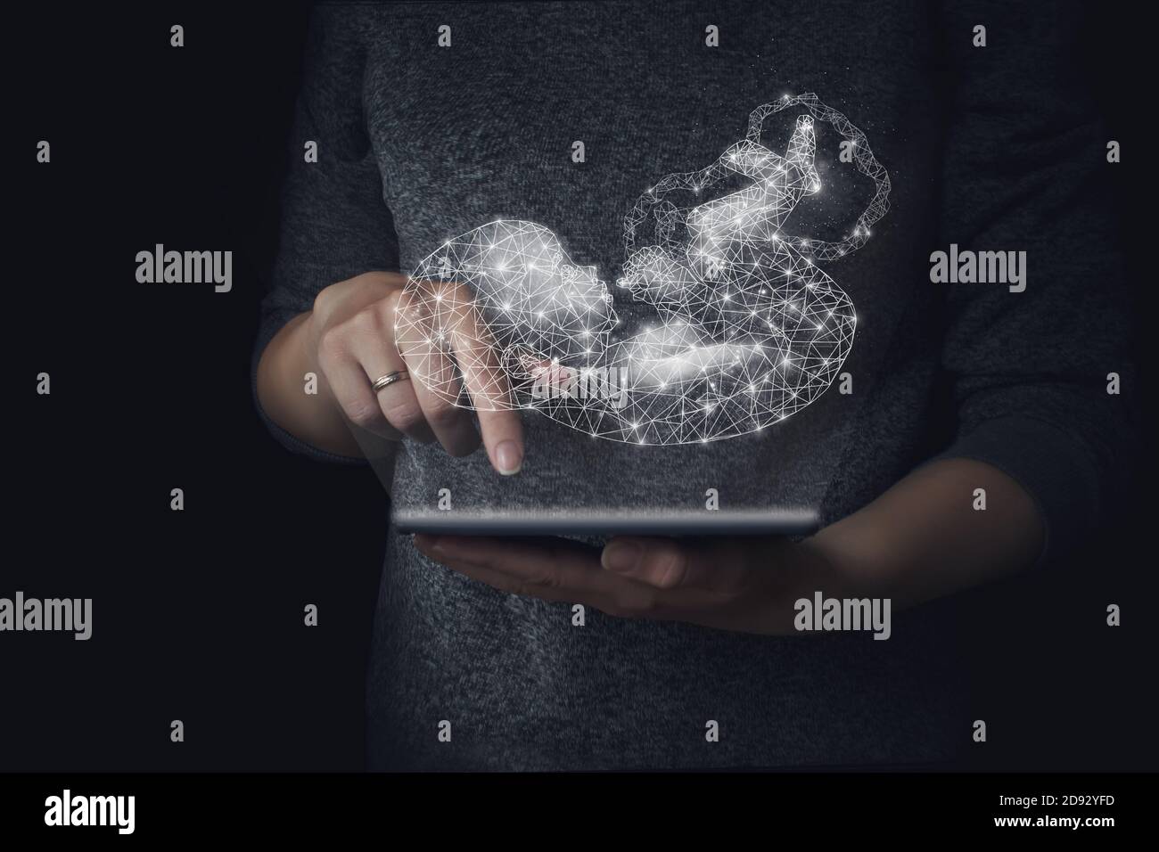 Gentechnik, Leihmutterschaft, Embryologie. Ein Hologramm eines Babys im Hintergrund der Hand hält eine Tablette, genetische Analyse in der Schwangerschaft plannin Stockfoto