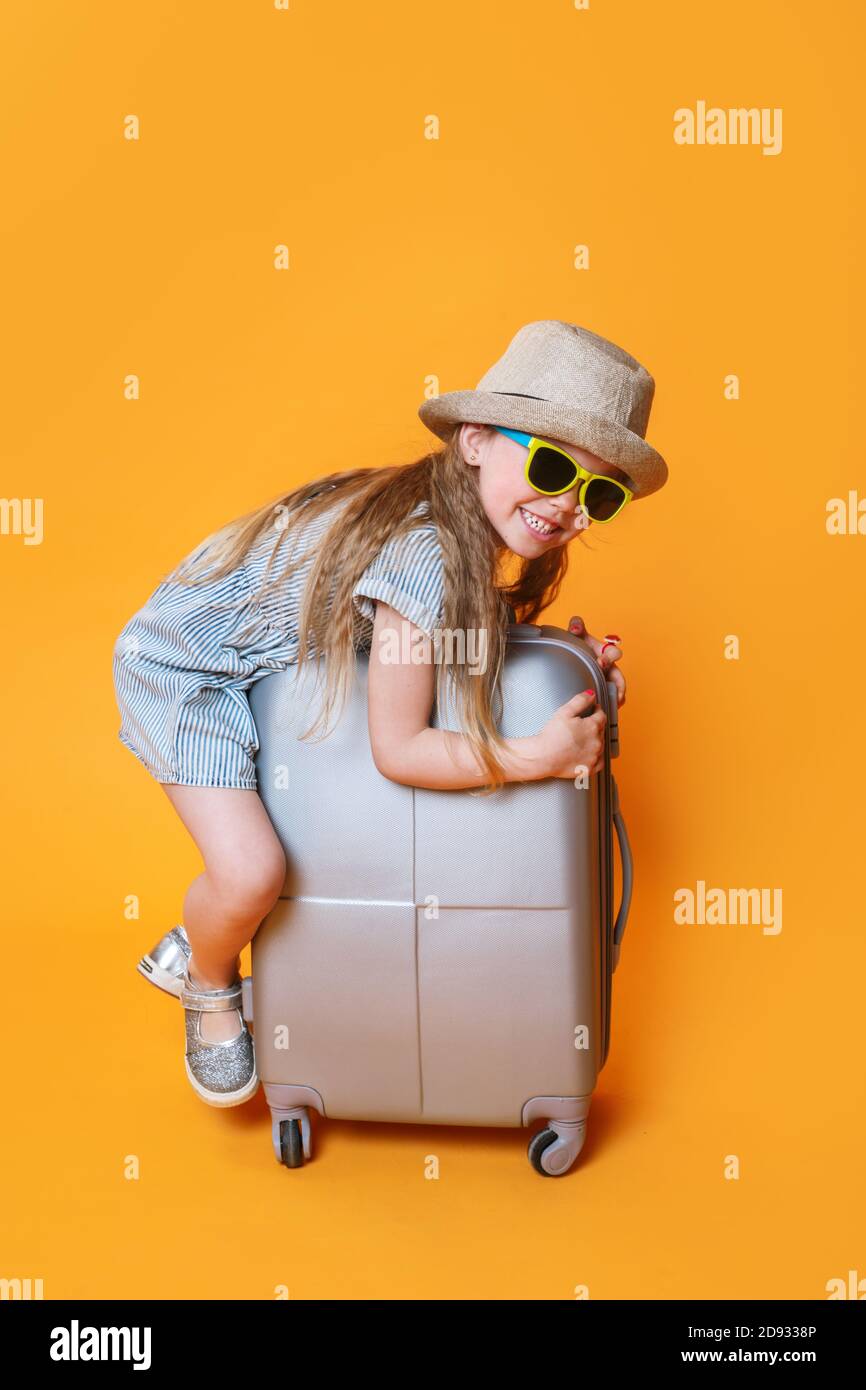 Ein Baby in der Sonnenbrille seiner Mutter sitzt in einem Auto in einem  Kindersitz und zeigt seine Zunge aus dem Fenster Stockfotografie - Alamy