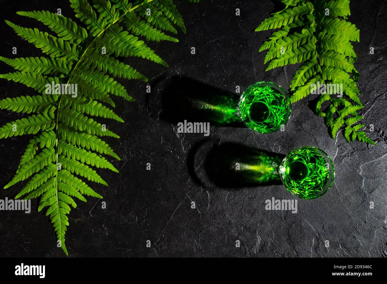 Starker Alkohol. Schnapsgläser mit Absinth. Hintergrund aus dunklem Stein Stockfoto