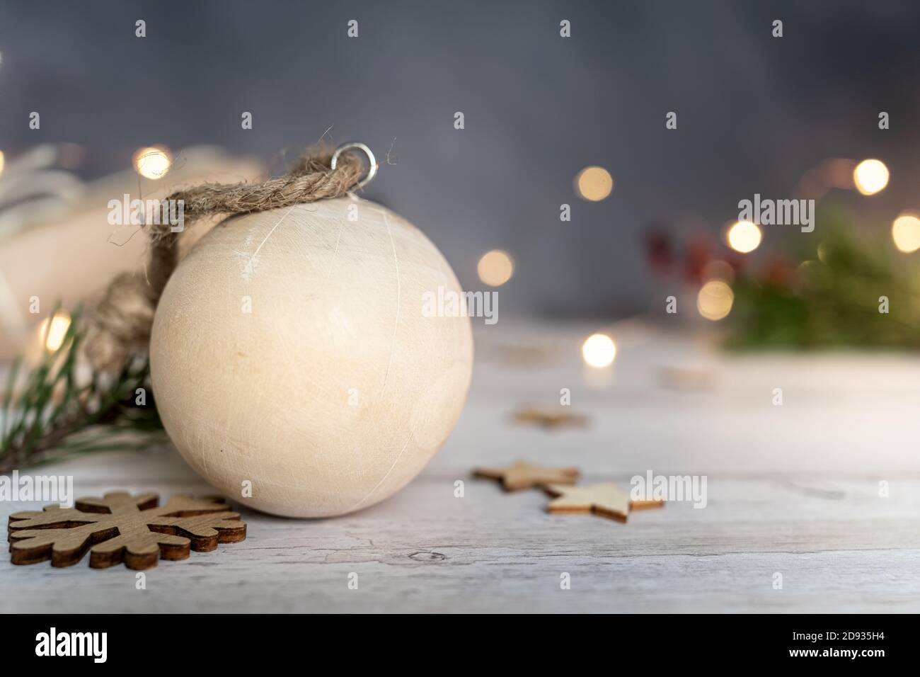 Weihnachten und Null Abfall, Holzkugel und Schneeflocken ein auf einem Holztisch. Lichter auf einem dunklen Hintergrund. Ökologische Weihnachtsfeiertagskonzept, Öko-Dekor Stockfoto