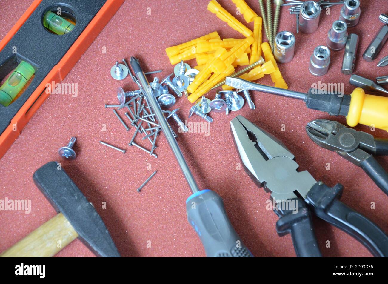 Draufsicht auf Arbeitswerkzeuge, Schraubenschlüssel, Steckschlüssel, Hammer, Schraubendreher, Zange, elektrische Bohrmaschine, Maßband, Maschinist Quadrat auf Holzbrett. Flaches Lay-Design. Stockfoto