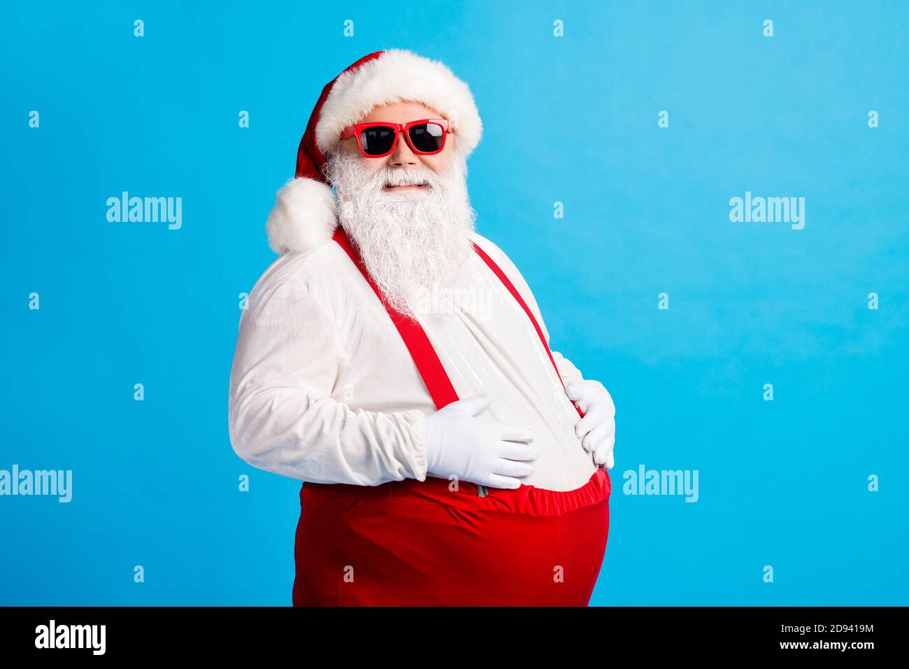 Foto von verrückten übergewichtigen weihnachtsmann berühren seinen großen  Bauch Genießen Sie Weihnachten weihnachten Neujahr Tradition Fest tragen  Kappe Hosenträger Overalls Isoliert über Stockfotografie - Alamy