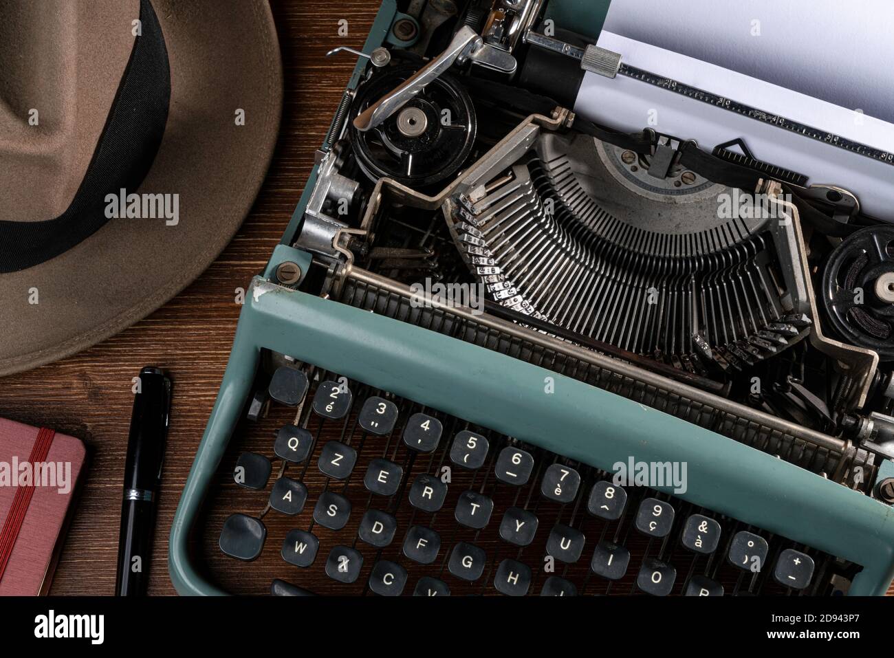 Ein Mann, der darüber nachdenkt, was er mit einer alten Schreibmaschine schreiben soll, Stockfoto
