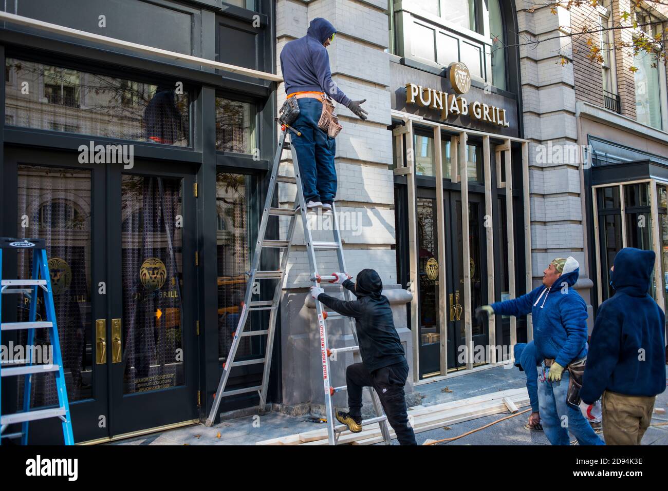 Washington DC, USA, 2. November 2020. Männer bei der Arbeit werfen ein Bauwerkzeug für das Einsteigen Unternehmen Ladenfronten in der Nation Capitol einen Tag vor t Stockfoto