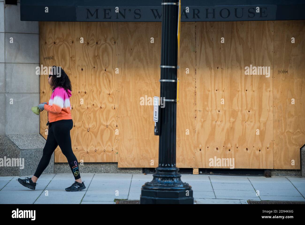 Washington DC, USA, 2. November 2020. Ein Fußgänger, der an einer bedeckten Schaufenster vorbeikommt und einen Tag vor dem eine dystopische Ansicht des Kapitols der Nation enthüllt Stockfoto