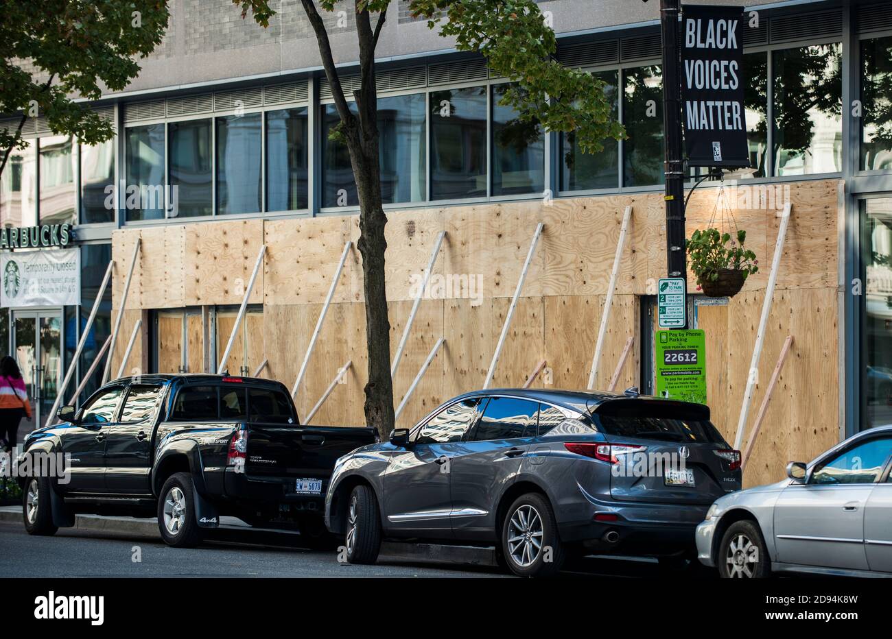 Washington DC, USA, 2. November 2020. Autos parkten entlang einer vereisten Geschäftshalle, während ein Schild mit der Aufschrift "Black Voices Matter" an einer Straße angebracht ist Stockfoto