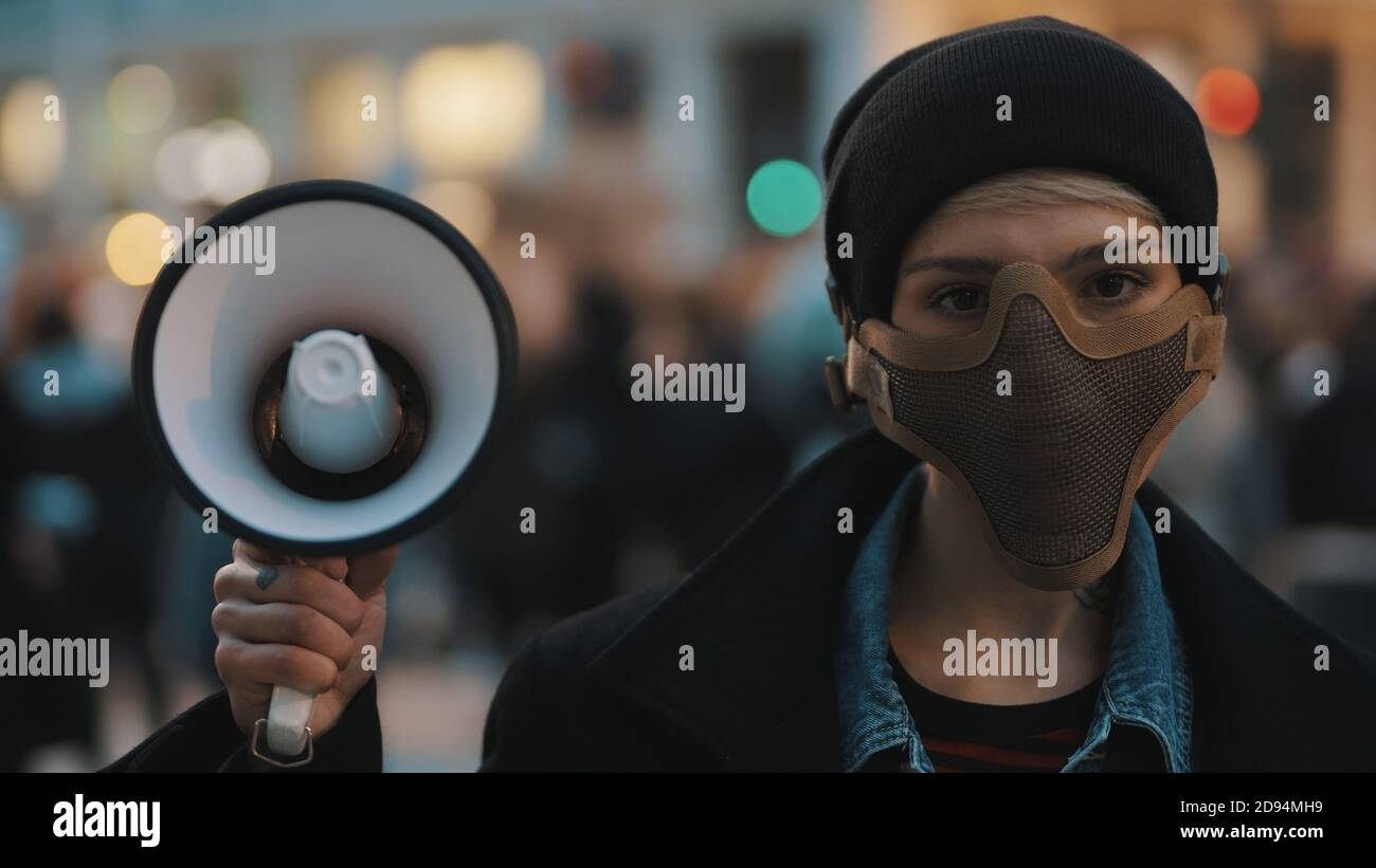 Frau mit Gesichtsmaske und Megaphon, die Anti-Rassismus-Proteste unterstützt. Hochwertige Fotos Stockfoto
