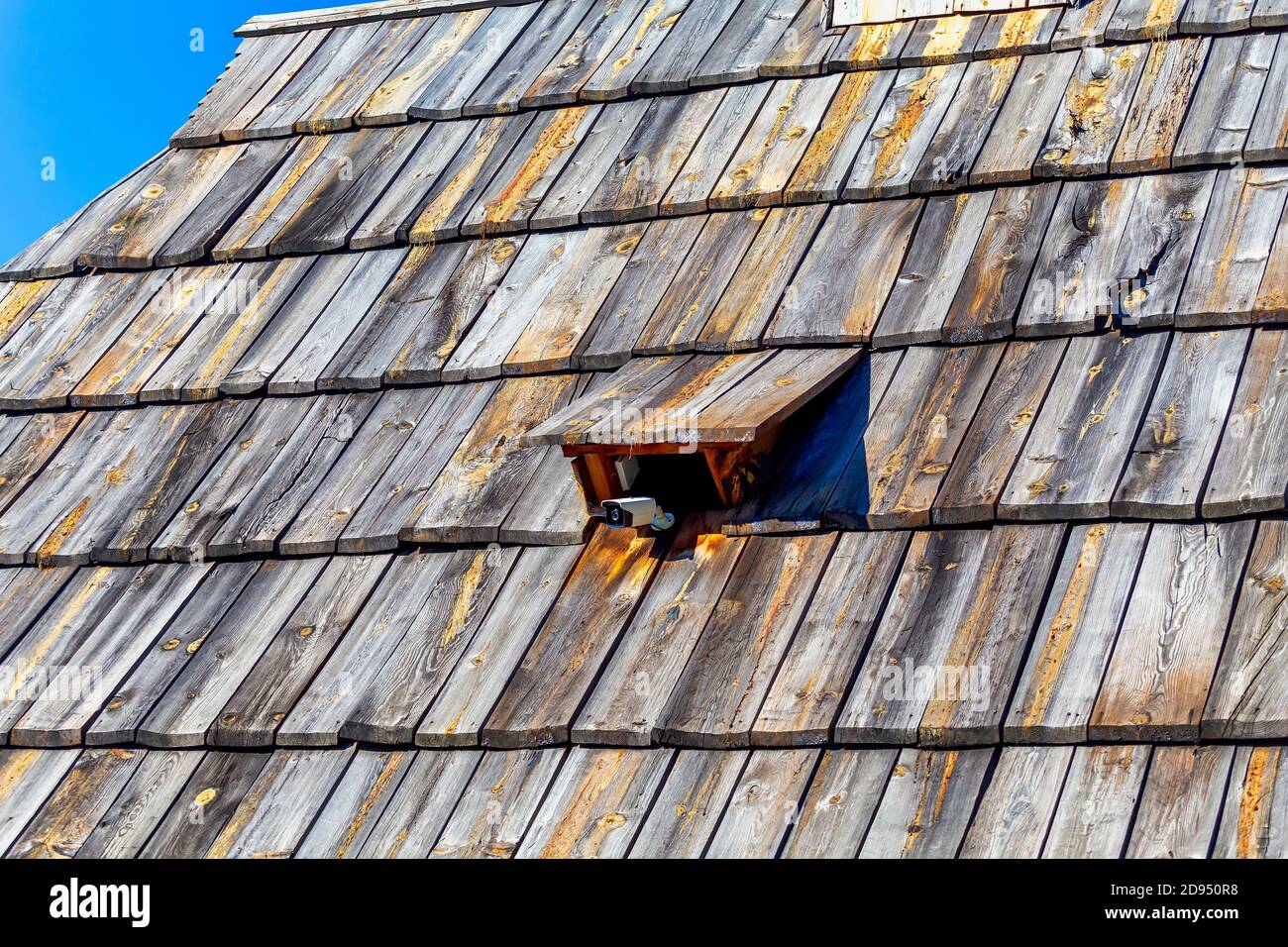 Sicherheit auf dem Land Ort Hintergrund. CCTV-Überwachungskamera auf der alten Holzdachziegel befestigt. Stockfoto