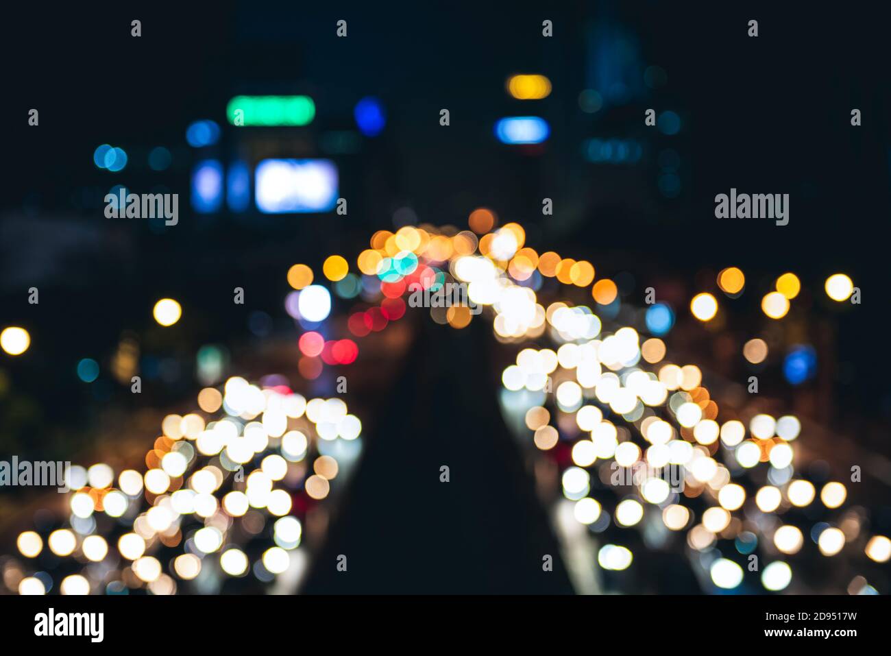 Verschwommener Blick auf die Straße von Bangkok bei Nacht mit lebhaftem Licht von Autos und Gebäuden, Bokeh Hintergrundkonzept Stockfoto
