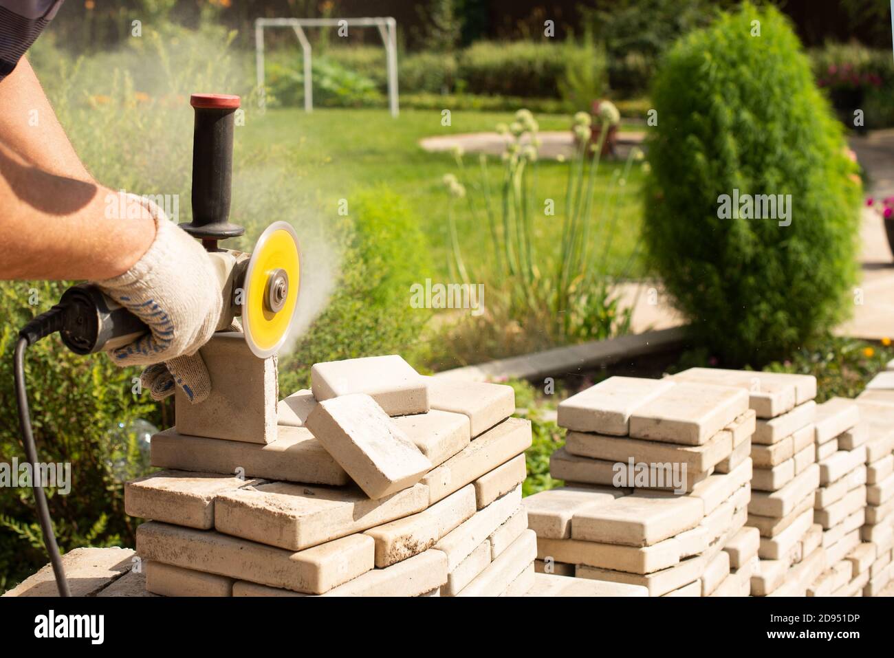 Master Sägen Pflaster Platten mit einem Schleifer Mühle. Staub. . Stockfoto