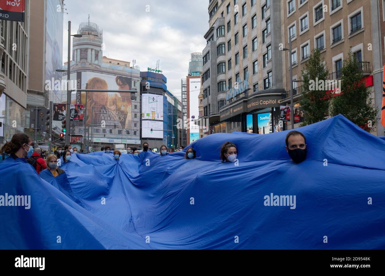 Während der Demonstration werden Aktivisten in den blauen Stoffen gesehen, während sie auf der Straße marschieren.während der dritten internationalen Rebellion blockierte die Bewegung Extinction Rebellion die Gran Vía Straße in Madrid, um gegen die Folgen des steigenden Meeresspiegels zu protestieren. Die Bewegung, die ein 150 Quadratmeter blaues Tuch vom Callao-Platz zum spanischen Platz trägt, marschiert über die Gran Vía-Straße, um die wachsende Zahl der Menschen sichtbar zu machen, die vom Anstieg des Meeresspiegels, verursacht durch den Klimawandel, betroffen sind. Dieser Akt unter dem Namen "Wir sinken" hat die große Zahl der Todesfälle durch den Anstieg des Meeresspiegels dargestellt. Stockfoto