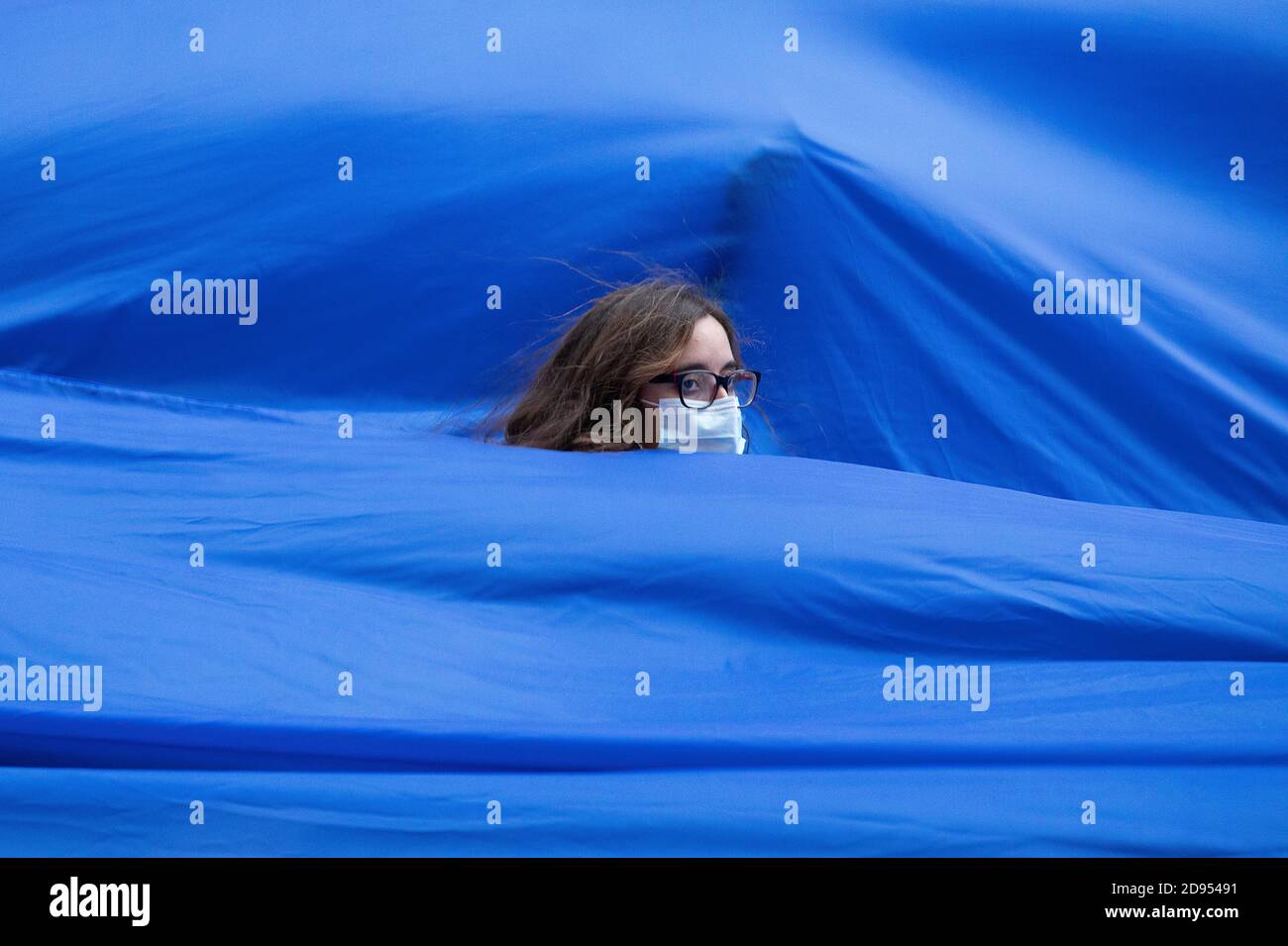 Ein Aktivist, der vollständig mit dem blauen Tuch bedeckt ist, das den Anstieg des Meeresspiegels symbolisiert, nimmt an der Demonstration Teil.während der dritten internationalen Rebellion blockierte die Bewegung Extinction Rebellion die Gran Vía Straße in Madrid, um gegen die Folgen des steigenden Meeresspiegels zu protestieren. Die Bewegung, die ein 150 Quadratmeter blaues Tuch vom Callao-Platz zum spanischen Platz trägt, marschiert über die Gran Vía-Straße, um die wachsende Zahl der Menschen sichtbar zu machen, die vom Anstieg des Meeresspiegels, verursacht durch den Klimawandel, betroffen sind. Dieser Akt, unter dem Namen "Wir sinken", hat die große Zahl der Todesfälle durch t dargestellt Stockfoto