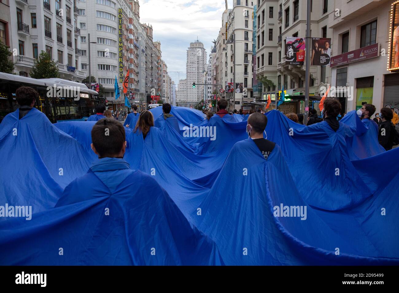 Während der Demonstration werden Aktivisten in den blauen Stoffen gesehen, während sie auf der Straße marschieren.während der dritten internationalen Rebellion blockierte die Bewegung Extinction Rebellion die Gran Vía Straße in Madrid, um gegen die Folgen des steigenden Meeresspiegels zu protestieren. Die Bewegung, die ein 150 Quadratmeter blaues Tuch vom Callao-Platz zum spanischen Platz trägt, marschiert über die Gran Vía-Straße, um die wachsende Zahl der Menschen sichtbar zu machen, die vom Anstieg des Meeresspiegels, verursacht durch den Klimawandel, betroffen sind. Dieser Akt unter dem Namen "Wir sinken" hat die große Zahl der Todesfälle durch den Anstieg des Meeresspiegels dargestellt. Stockfoto